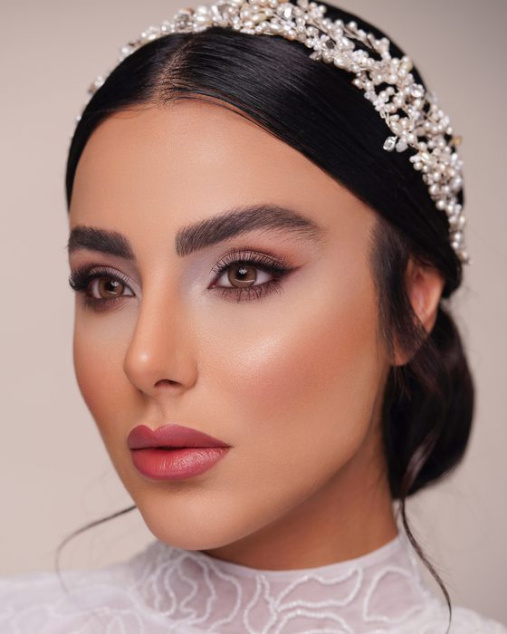 Kühle Taupe- und Perlmutt-Töne, weich auslaufende Smokey Eyes und glänzende Rosé-Lippen schaffen einen modernen und makellos polierten Bridal Look.