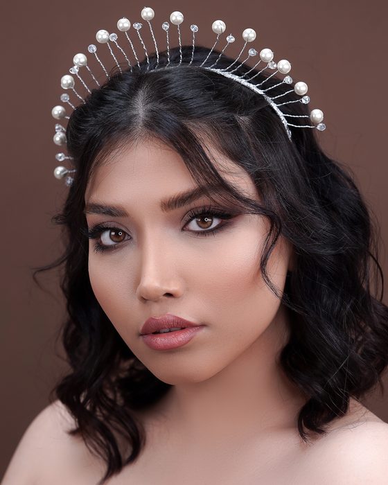 Moderner Bridal Look mit soften Mocha- und Taupe-Tönen, dunklen Wellen, glänzenden Nude-Lippen und außergewöhnlichem Perlenschmuck.