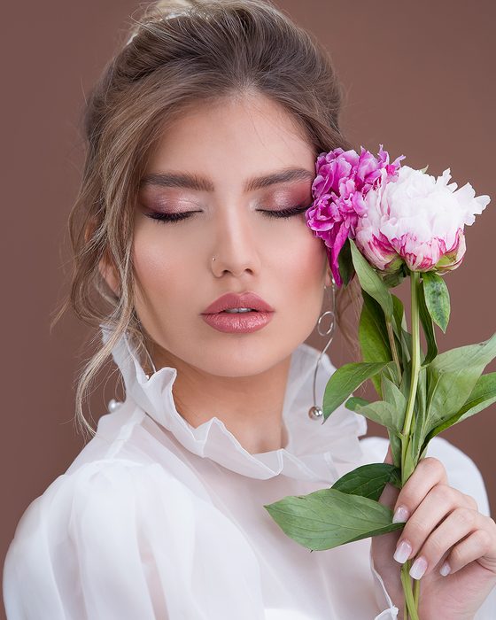 Moderner Bridal Look mit Rosewood- und Mauve-Tönen, präzise definierten Augen, rosigen Lippen und floraler Editorial-Inszenierung.