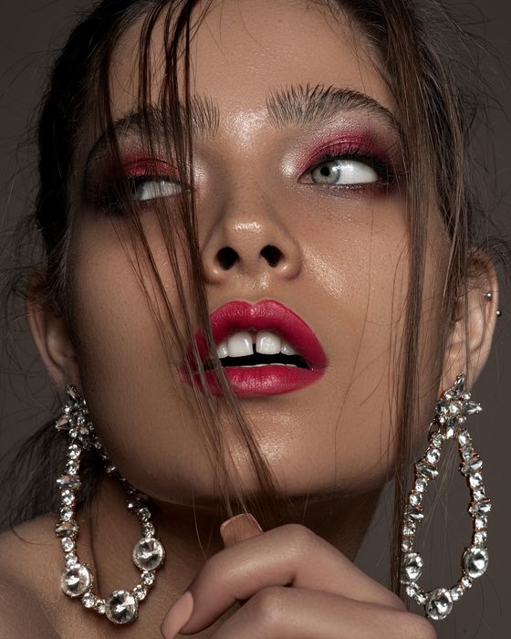 Ausdrucksstarker Editorial Look mit Rubin- und Beerentönen, intensivem Augen-Make-up und kräftigen Lippen.