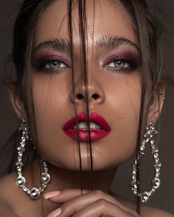 Ausdrucksstarker Editorial Look mit Rubin- und Beerentönen, intensivem Augen-Make-up und kräftigen Lippen.